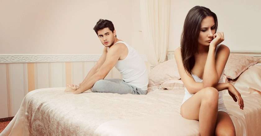 unhappy-young-couple-sitting-on-bed.jpg